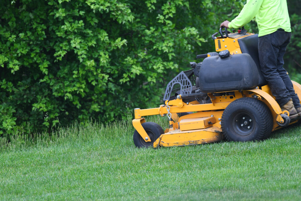 manual worker mowing the lawn